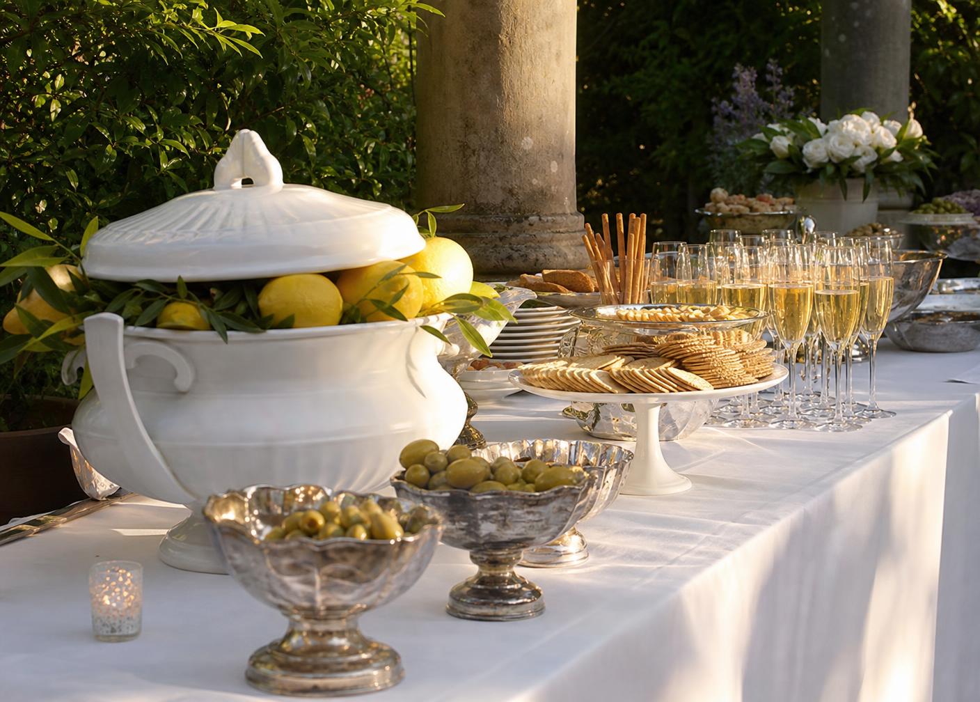 Buffetbord med hvit terrin, sølvboller og champagneglass